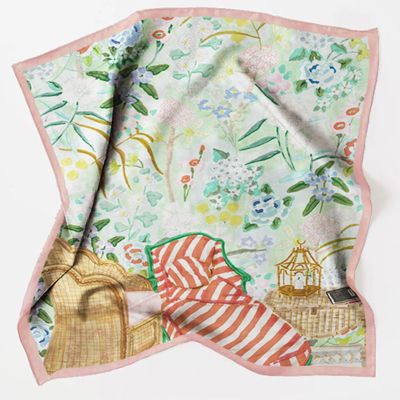 Printed silk scarf displayed on a wooden hanger